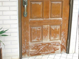 玄関の塗装が剥がれ色褪せた状態の写真